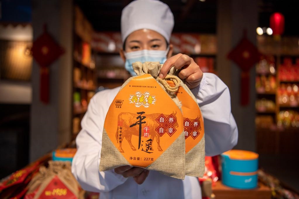 1月27日，在平遙古城南大街的一家平遙牛肉店內(nèi)，工作人員展示一款牛肉產(chǎn)品。新華社記者 楊晨光 攝