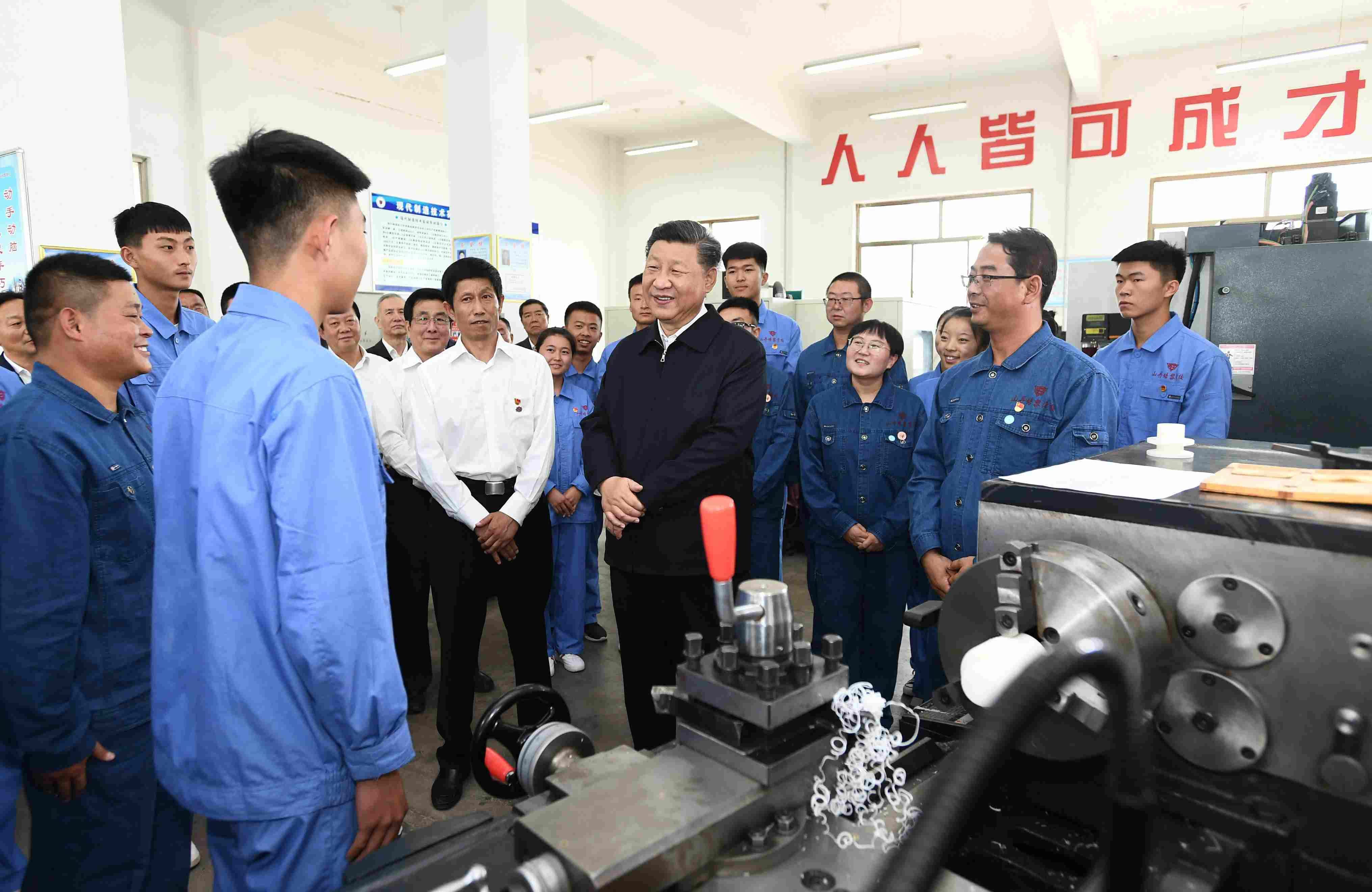2019年8月20日，習(xí)近平在甘肅省張掖市山丹培黎學(xué)?，F(xiàn)代制造技術(shù)實(shí)訓(xùn)室，觀看職業(yè)技能實(shí)訓(xùn)，同師生親切交流。
