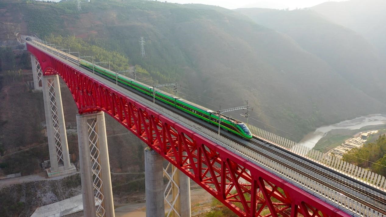 中老鐵路國際旅客列車在云南省境內(nèi)的元江特大橋上飛馳。姚巍攝