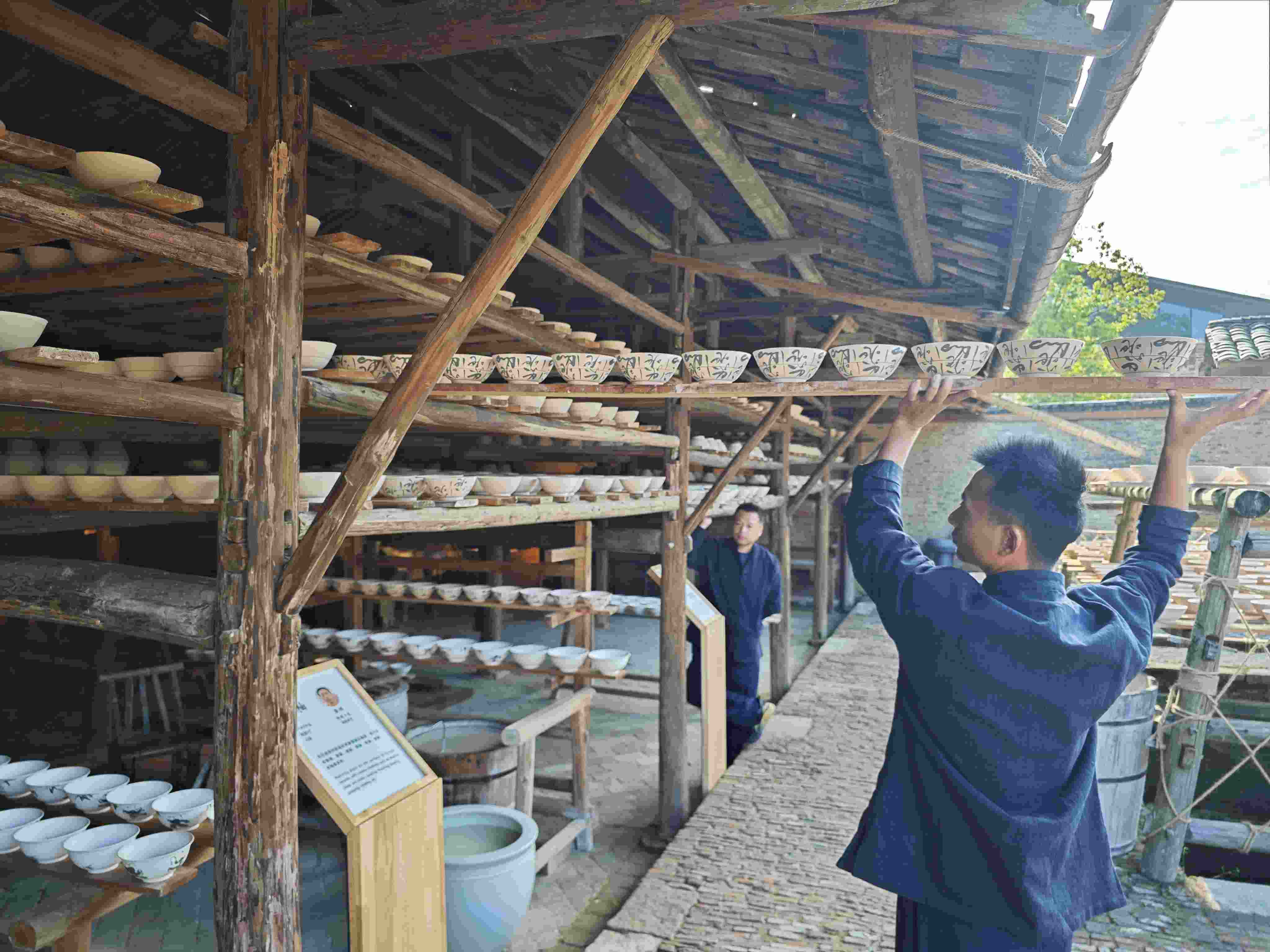 △陶陽(yáng)里歷史文化街區(qū)里，工匠將陶瓷工藝品放到架上晾干。（總臺(tái)央視記者彭漢明拍攝）