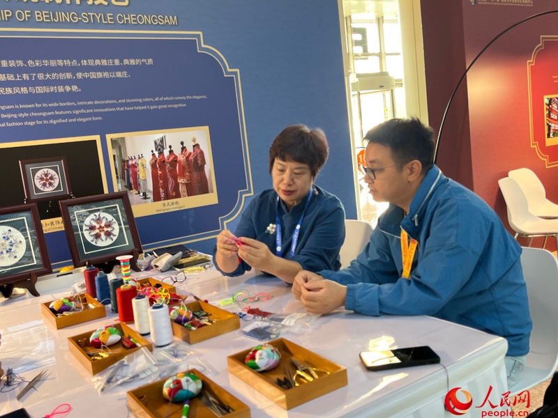 記者在新聞中心非遺傳承人展區(qū)進行體驗。人民網(wǎng)記者 杜燕飛攝
