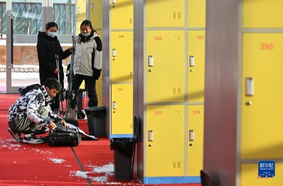 12月21日，游客在滑雪服務(wù)大廳整理滑雪裝備。