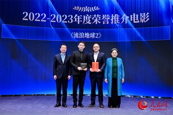著名電影藝術(shù)家、事業(yè)家王曉棠（右一）和中國文聯(lián)書記處書記張宏（左一）為《流浪地球2》出品人、總監(jiān)制、總制片人傅若清（右二）與導(dǎo)演郭帆（左二）頒發(fā)“2022-2023年度榮譽(yù)推介電影”