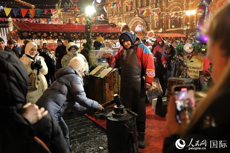 游客在新年集市上體驗制作紀(jì)念幣。人民網(wǎng)記者 隋鑫攝