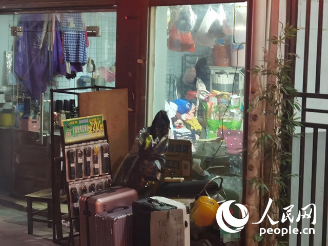 南寧“城中村”一裁縫鋪老板將電線從店內(nèi)拉出為電動(dòng)自行車充電。人民網(wǎng) 覃心攝