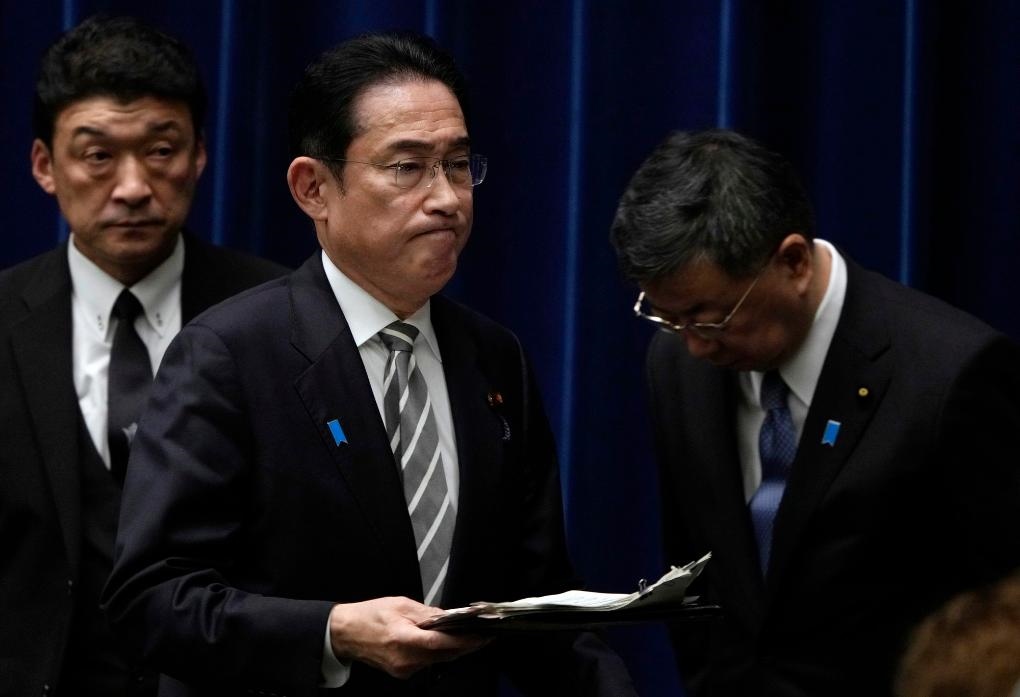 2023年12月13日，日本首相岸田文雄（中）在日本東京首相官邸召開(kāi)記者會(huì)后走過(guò)時(shí)任內(nèi)閣官房長(zhǎng)官松野博一（右）。新華社發(fā)（Pool圖片，弗蘭克·羅比雄攝）