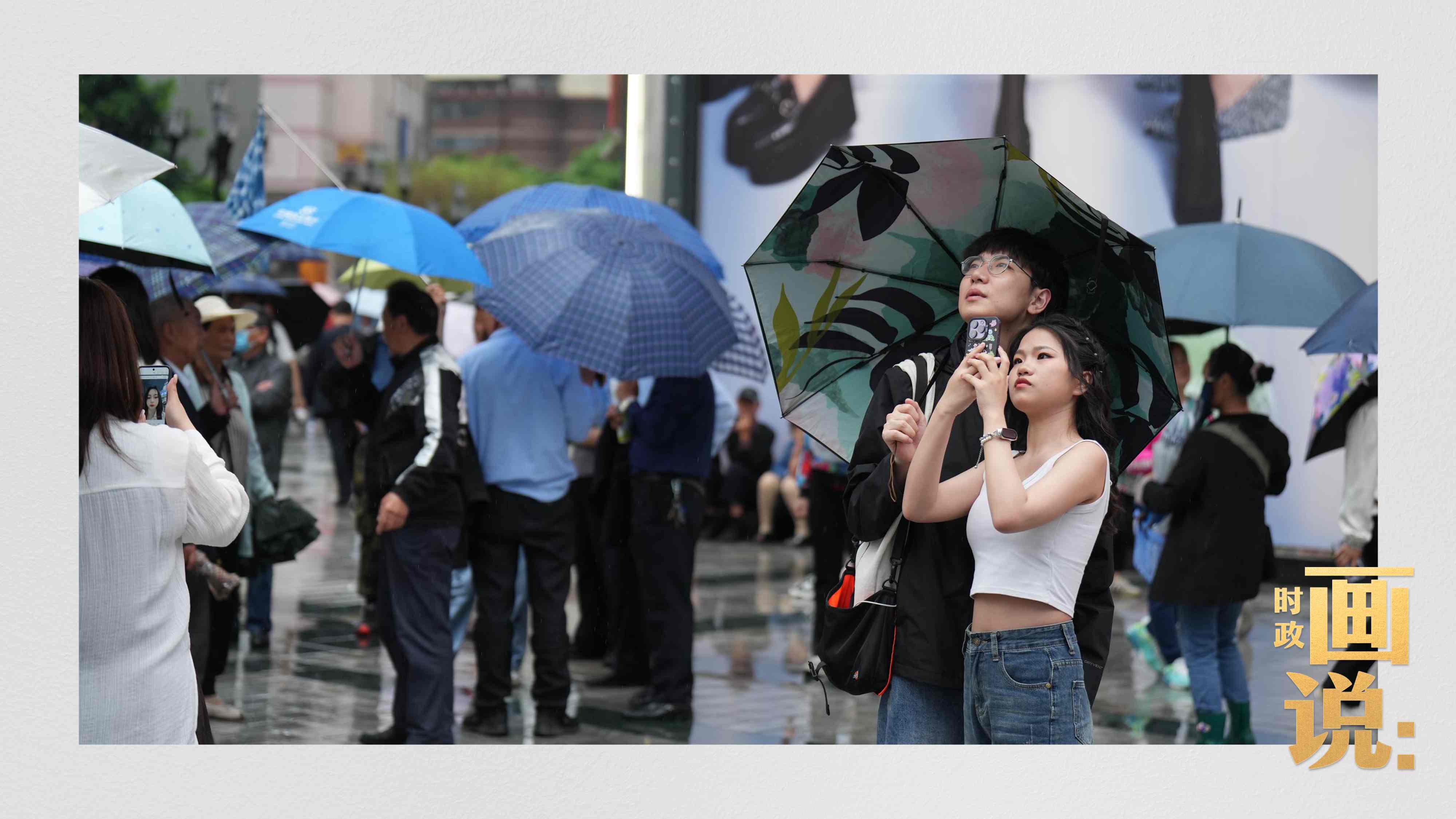 △細(xì)雨中的解放碑步行街，騎在父親肩膀的小女孩好奇張望。