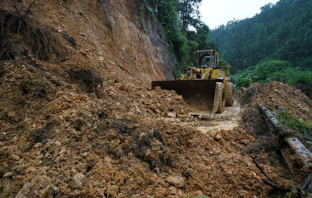 6月18日，在廣西融水苗族自治縣融水鎮(zhèn)新安村，一臺推土機在清理塌方路段。新華社發(fā)（龍林智攝）