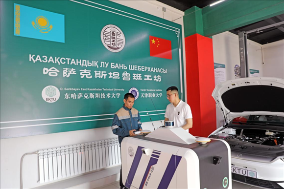 在哈薩克斯坦魯班工坊汽車維修技術實訓區(qū)，兩名技術員正在操作調試由中方提供的智能機器人車。哈薩克斯坦魯班工坊位于東哈薩克斯坦州首府厄斯克門，該項目由天津職業(yè)大學與東哈薩克斯坦技術大學共同承建，于2023年12月9日開始試運行。本報記者 趙益普 攝