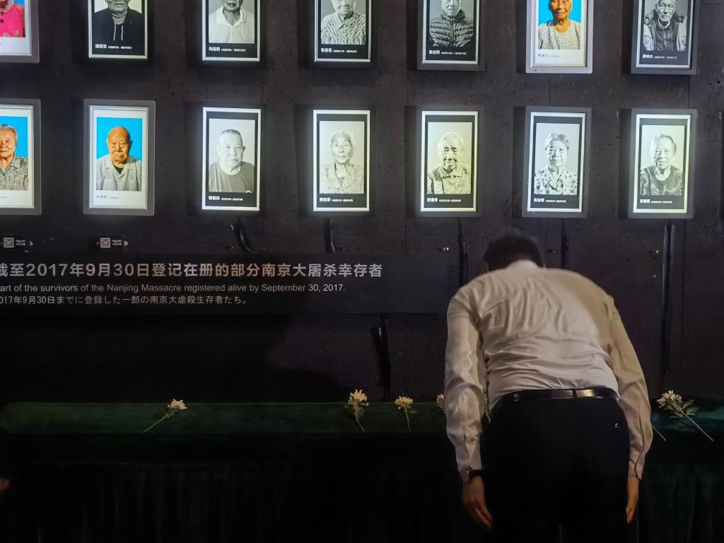 7月18日，人們向離世的南京大屠殺幸存者獻花、鞠躬。新華社記者邱冰清 攝