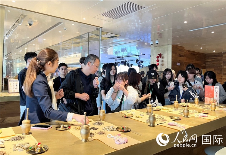 1. 日中友好協(xié)會(huì)青年代表團(tuán)一行學(xué)習(xí)中醫(yī)香囊制作工序。（人民網(wǎng)記者陳思 攝）