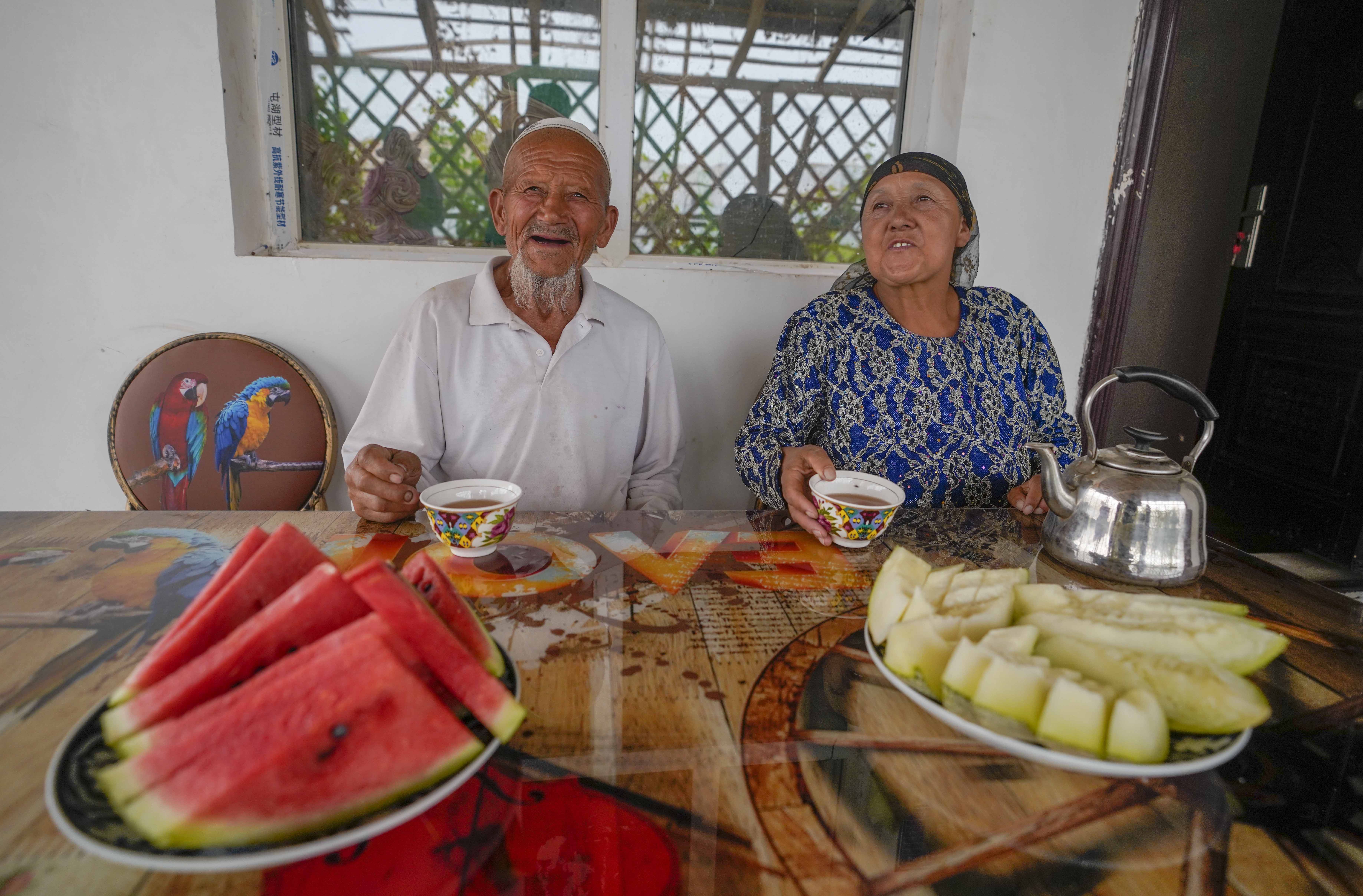 在新疆喀什地區(qū)伽師縣江巴孜鄉(xiāng)依帕克其村57號，80歲的維吾爾族老人伊米提·艾山（左）在自家庭院中（2020年6月8日攝）。