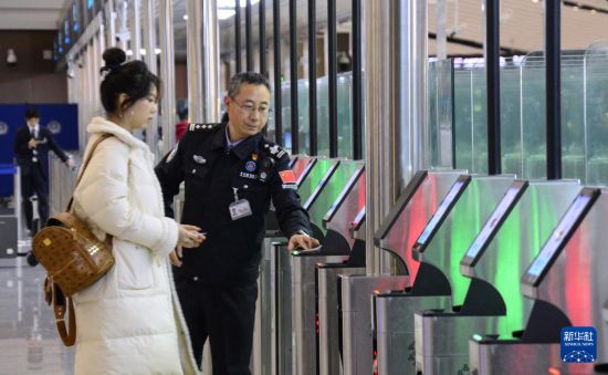 1月2日，大興機場邊檢站警察指導(dǎo)旅客使用自助出境設(shè)備。新華社記者 李欣 攝