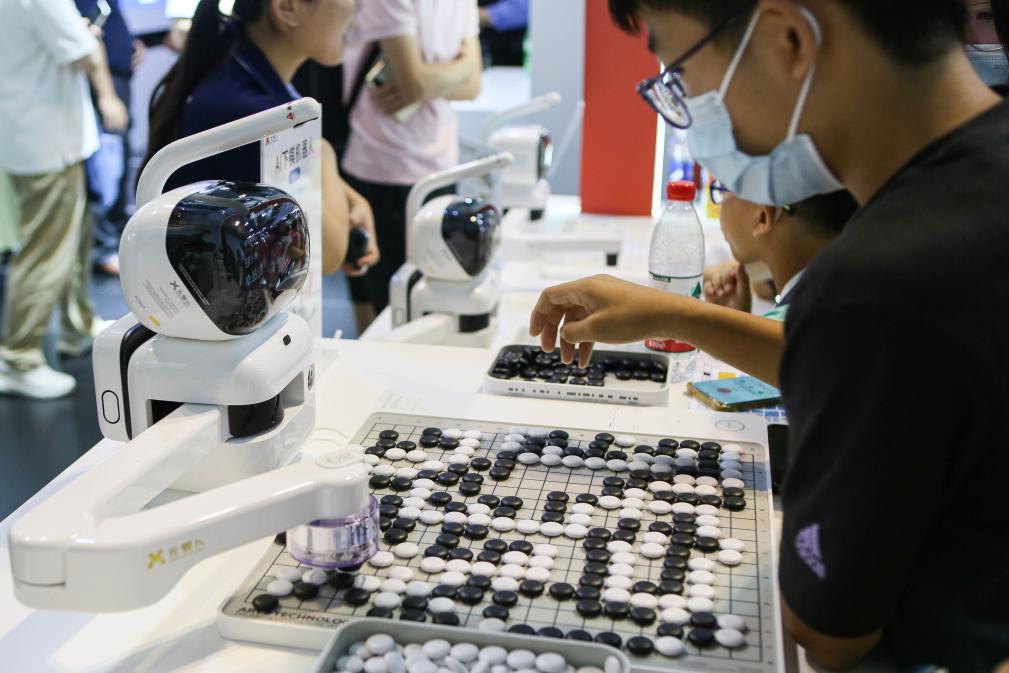 2023年7月7日，元蘿卜AI下棋機(jī)器人與觀眾對弈。2023年7月6日至8日，2023世界人工智能大會在上海舉行。新華社記者 辛夢晨 攝