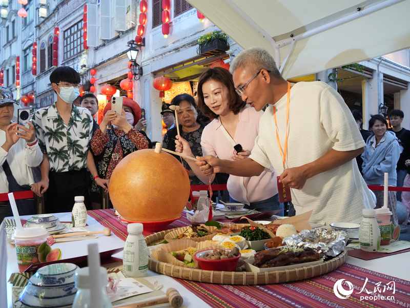 嘉賓品嘗海南傳統(tǒng)美食“煎堆”。人民網記者 張力洋攝