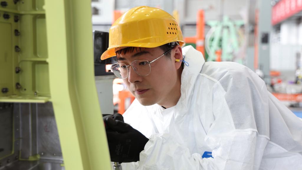 在中國(guó)航空工業(yè)集團(tuán)成飛車間內(nèi)，飛機(jī)鉚裝鉗工首席操作技師馮攀龍正在工作。（新華社發(fā)）