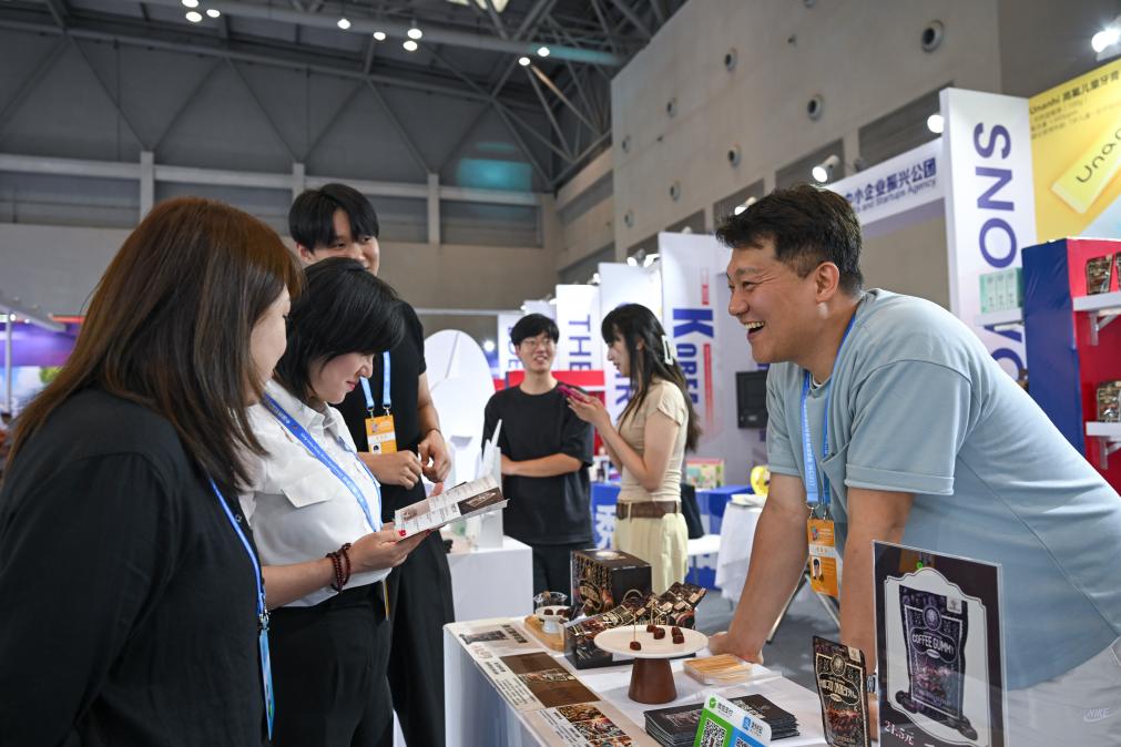 5月22日，韓國展商（右一）在西洽會現(xiàn)場向參觀者介紹產(chǎn)品。新華社記者 陳誠 攝
