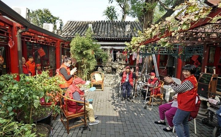 2024年10月12日，鐘樓灣胡同的老年人在社區(qū)內(nèi)的四合院養(yǎng)老驛站休閑。2017年起，北京市先后開(kāi)展了兩輪背街小巷環(huán)境整治提升行動(dòng)，完整保留了中軸線生活建筑群的歷史信息，并根據(jù)居民的生活和居住方式進(jìn)行適配化的更新和改造，極大地改善了生活環(huán)境。2023年鐘樓灣胡同被評(píng)為“北京最美街巷”。